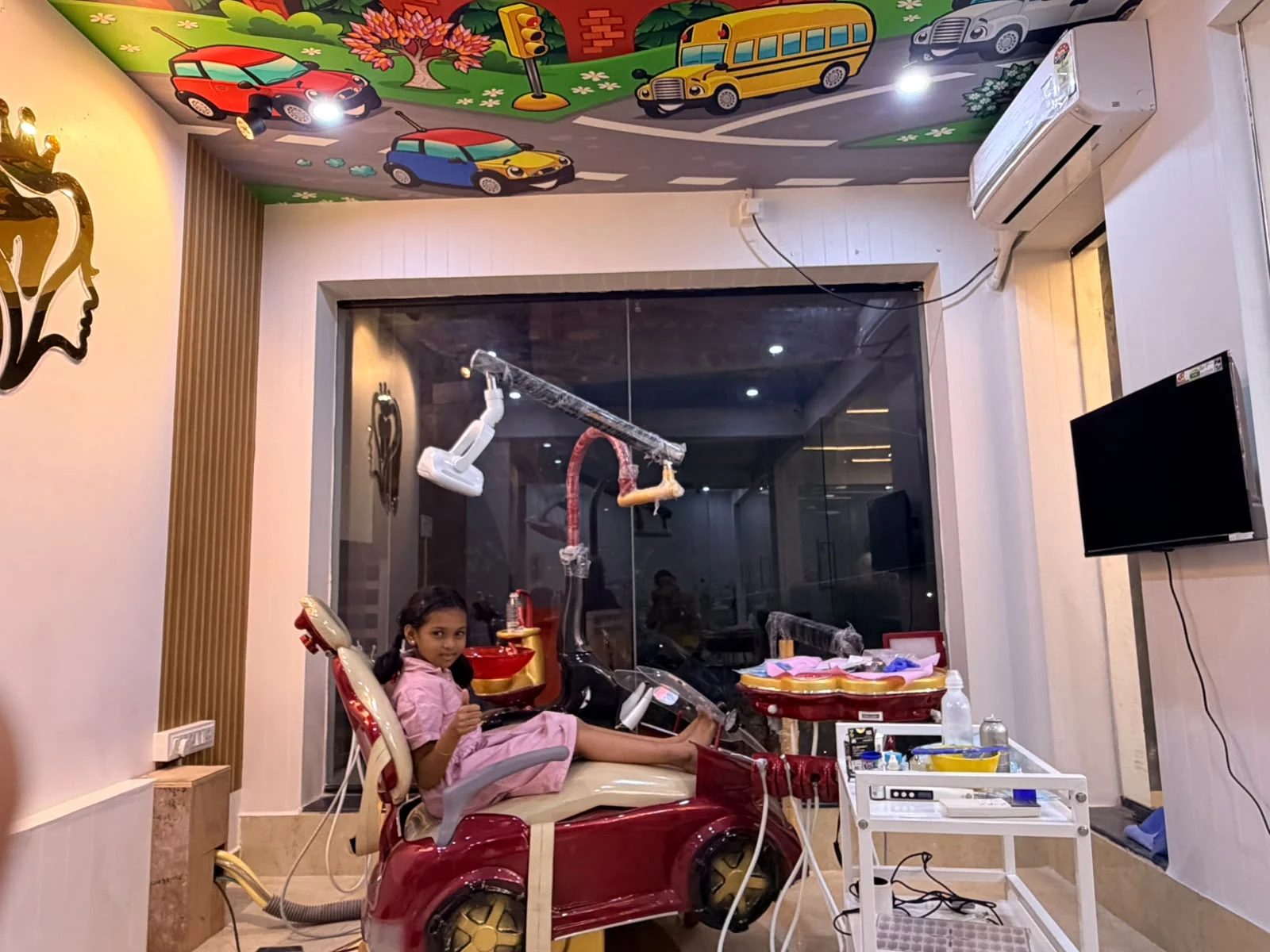 Child enjoying the car-themed dental chair at The Golden Crown Adambakkam